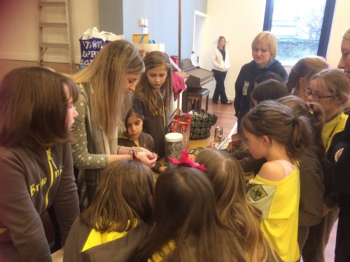Brooke teaching Girl Guides how to make ring pull bracelets.